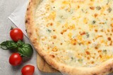Delicious cheese pizza, basil and tomatoes on light grey table, flat lay