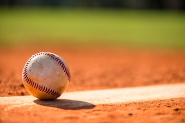 Worn baseball on Pitcher's Mound with dirt and grass in background