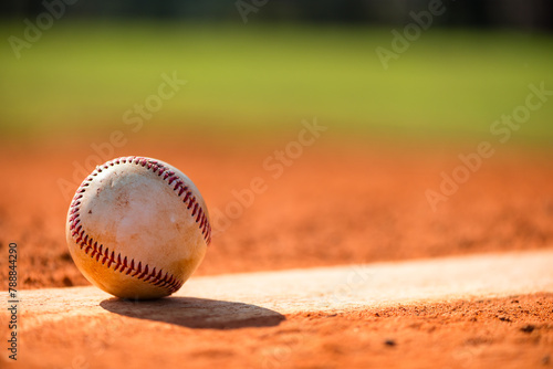 Worn baseball on Pitcher's Mound with dirt and grass in background