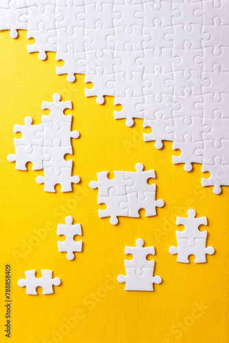 Jigsaw puzzle for business concept on yellow background. Idea of partnership and teamwork. Vertical poster