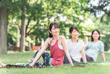 新緑の公園でヨガ教室をする女性達（パークヨガ・瞑想・ピラティス）
