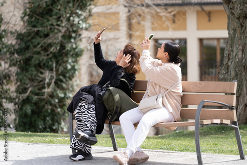 Salamanca España - 16 de marzo de 2024: Madre e hija están tomando fotos con su celular en una calle de la Ciudad de Salamanca.
