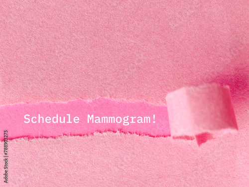 Text of schedule mammogram behind torn paper background. stock photo