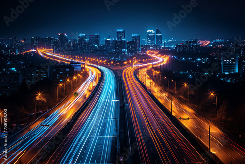 Streaks of moving car lights against the backdrop of city lights at night © PHTASH