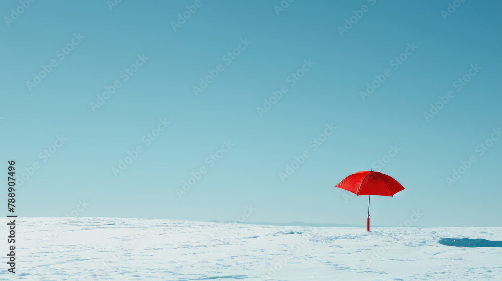 A bright red umbrella hovers over a white snowy field under a bright blue sky