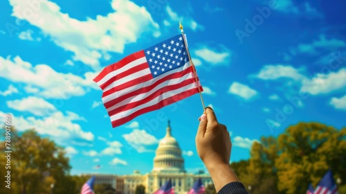 A symbolic image of a hand waving the American flag in front of iconic landmarks, such as the Statue of Liberty or the Capitol Building. photo