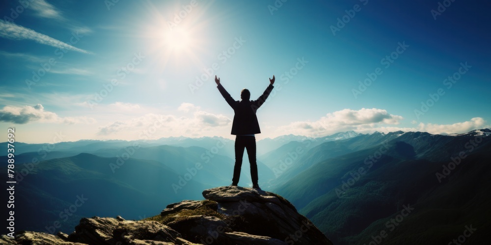Raising arms on top of mountain with blue sky and sunlight The concept of being a successful leader with goals, growth, and upwards.