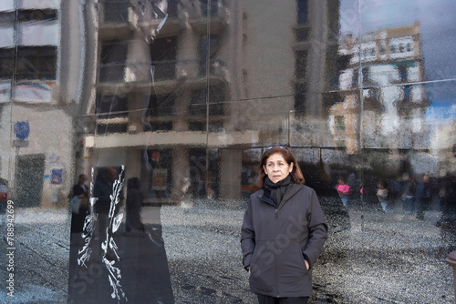 Sevilla España - 3 de marzo de 2024: La mujer está posando a un lado de una vaya publicitaria en una calle de Sevilla.
