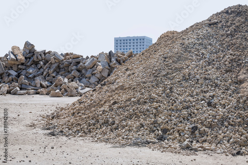A pile of gravel on the background of a pile of removed old curb stone