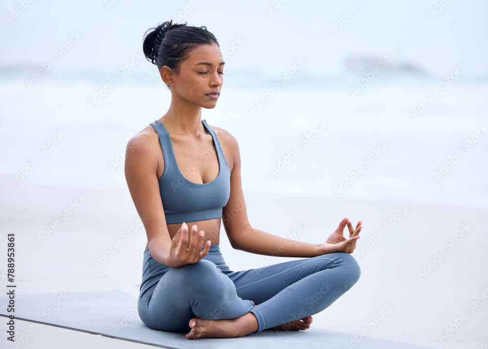 Yoga, lotus meditation and Indian girl at beach for mindfulness, peace or relax on mockup space. Zen, ocean and woman in padmasana pose for exercise, fitness and wellness for body healthy outdoor