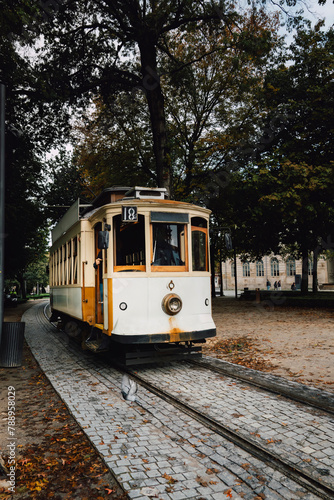 View of a park with the famous retro tourist streetcar in the old town of Porto, Portugal. Traditional Tram