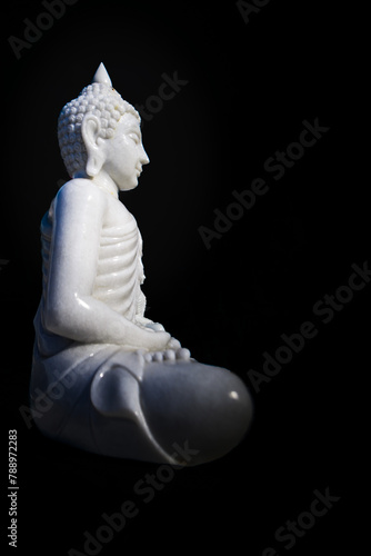 White Buddha statue with black background