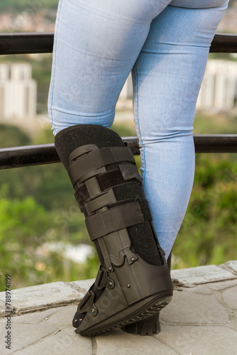 Young woman wearing splint for fractured fibula. Disability, free air and crutches.
