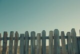 an image of an old, weathered wooden fence with varying plank heights