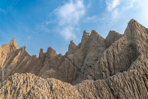 Bare hills with earthy textures stand out against the blue sky and white clouds. Caoshan Moon World is a chalky badland region tucked in the southern part of Tainan. 