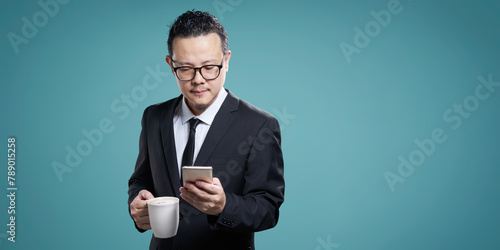 Businessman checking smartphone with coffee © jamesteohart