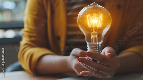 The woman delicately holds an automotive lighting bulb between her fingers