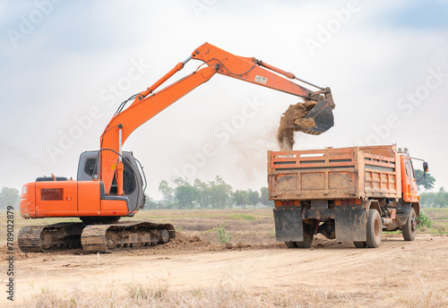 Backhoes loading soil onto a dump truck.