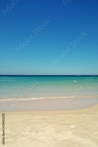 Atlantic ocean and beach with golden sand and blue sky in Tarifa, Spain. Playa de Bolonia on Atlantic coast of Tarifa, Province of Cadiz, Andalucia, southern Spain. Waves on Levante wind on summer day © Lidia