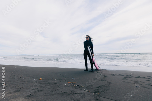 Photography Happy surfer woman in wetsuit with surfboard go to winter surfing in ocean