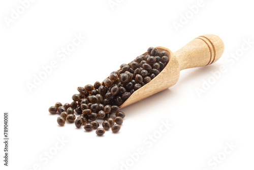 Front view of a wooden scoop filled with Fresh Organic Papaya (Carica papaya) seeds. Isolated on a white background.
