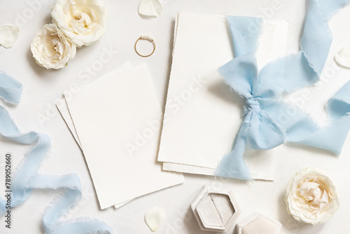 Cards tied with a light blue ribbons on white table top view, copy space, wedding stationery mockup