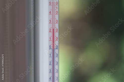 Outdoor thermometer behind the glass on a green blurred background © Robert A. Witkowski