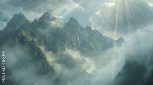 A dramatic mountain range shrouded in mist and clouds, with rays of sunlight breaking through the atmospheric veil, creating a mystical and ethereal landscape. photo