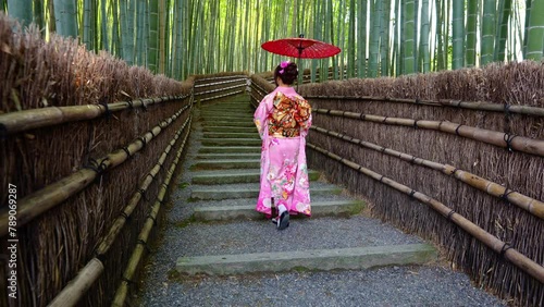 4k Slow motion video Asian woman wearing a traditional Japanese kimono at Bamboo Forest in Kyoto, Japan.