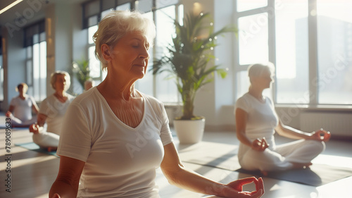 Older women practice yoga, meditate in yoga classes and lead an active and healthy lifestyle. Retirement hobbies and leisure activities for the elderly. Bokeh in the background. photo