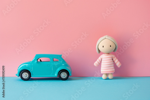 Gender stereotypical toys for children with car and  doll on two-colored pink and blue background © Firn