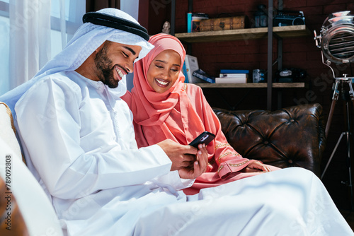 Happy middle eastern couple wearing traditional arab clothing at home © oneinchpunch