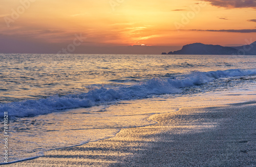 Colorful mediterranean sunset with surging waves on the beach in Alanya, Turkey.
