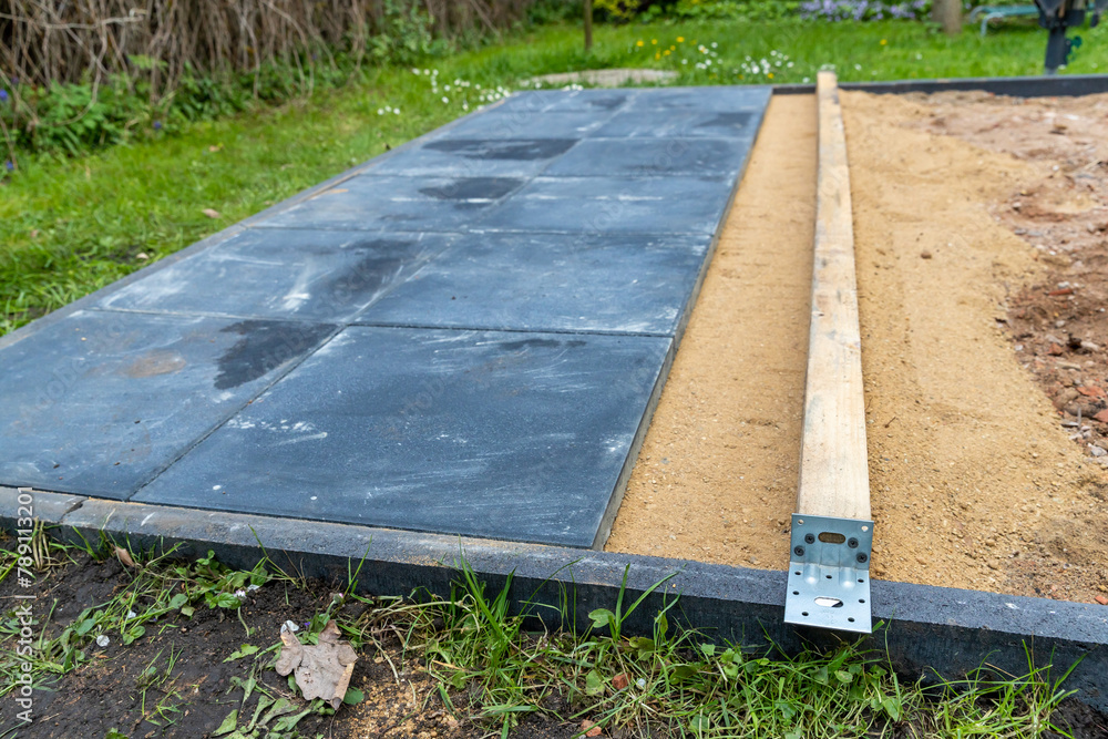 Sand als Unterbau gerade abziehen um Gehwegplatten darauf zu verlegen