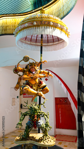 Bali March 2024 – Colorful Traditional demon ogoh-ogoh Balinese under a  cerimonial umbrella in Denpasar Airport, Bali, Indonesia photo