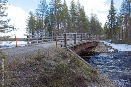 Bridge over Iikoski river in cloudy spring weather, Hossa National Park, Suomusslami, Finland. photo