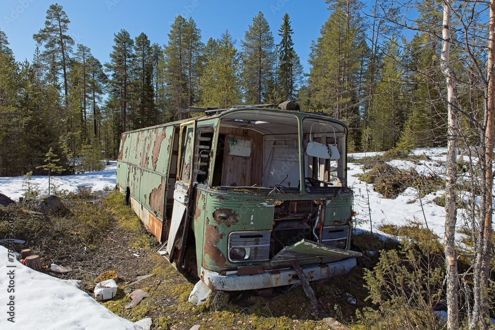 Old abandoned green bus in forest in clear spring weather with snow on the ground. Old abandoned green bus in forest in clear spring weather with snow on the ground.