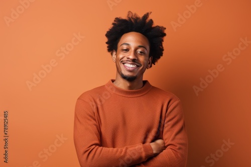 Portrait of a satisfied afro-american man in his 20s wearing a cozy sweater on solid color backdrop