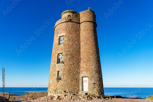 L'ancien phare du Cap Fréhel, emblème chargé d'histoire des Côtes d'Armor, trône majestueusement sur la côte bretonne, rappelant la grandeur passée de la navigation maritime dans la région. photo