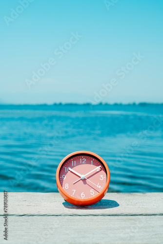 pink clock on a pier on a summer day