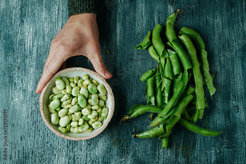broad bean pods and man with a bowl of broad beans © nito