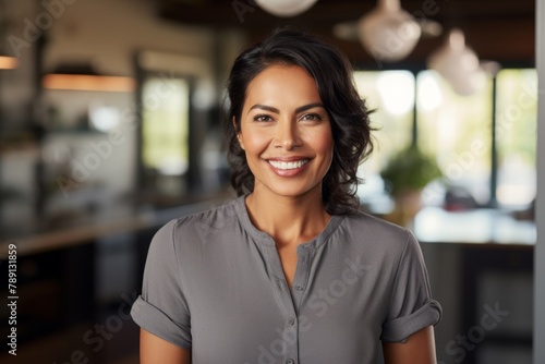 Portrait of a smiling indian woman in her 40s donning a classy polo shirt over scandinavian-style interior background