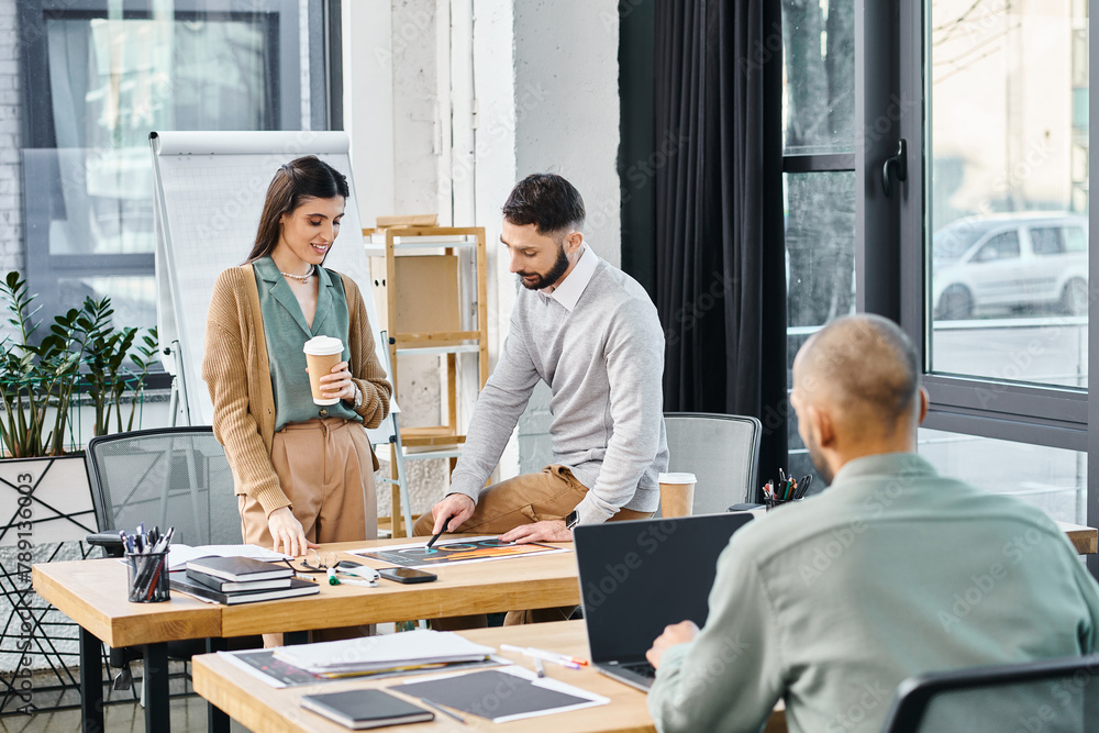 © Bliss - A group of professionals discussing a project while standing around a table in an office setting. © Bliss - A group of professionals discussing a project while standing around a table in an office setting.