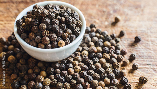 Fototapeta Naklejka Na Ścianę i Meble -  Black pepper seeds in a cup on the table, spices used in cooking