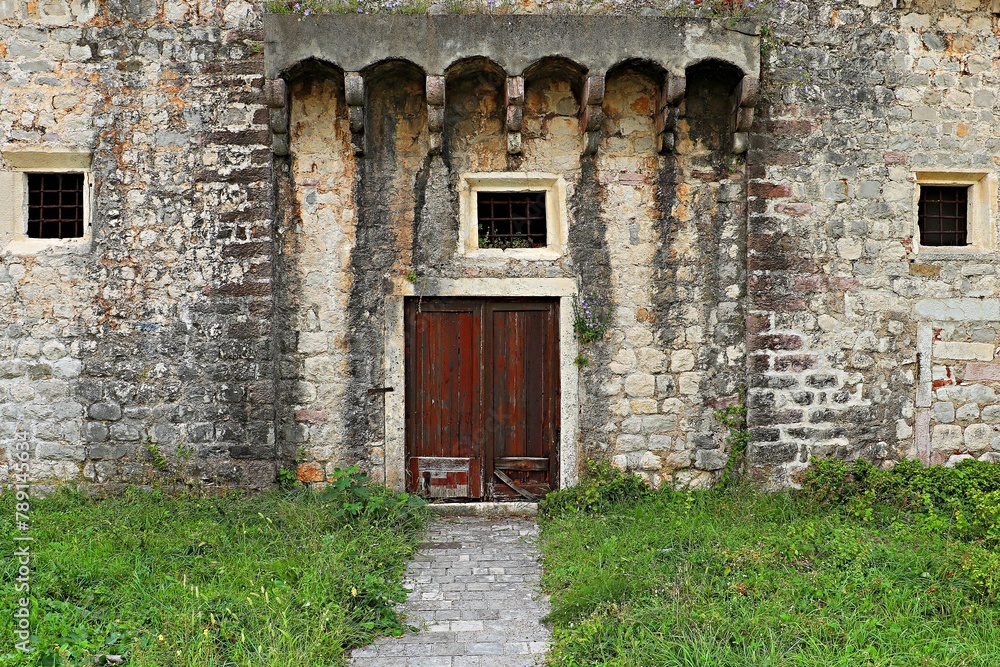 Fototapeta premium Old wooden door in an ancient stone house