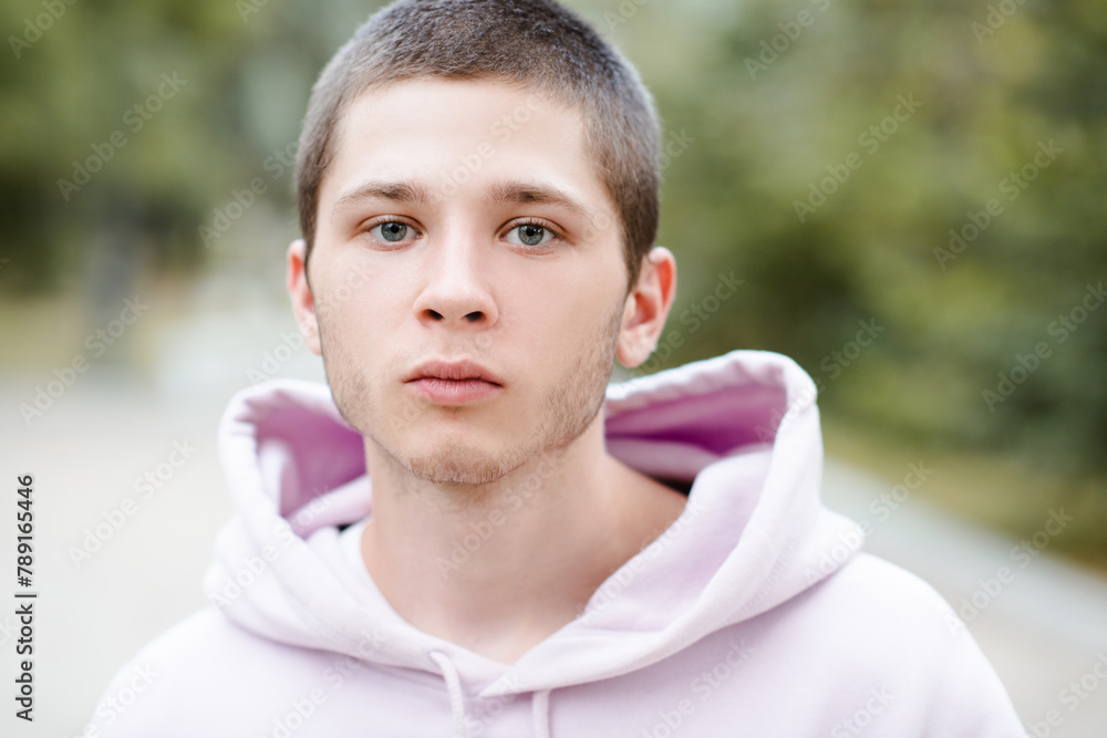 Handsome blond teenage boy 18-20 year old wearing hoodie looking at camera close up. Handsome blond teenage boy 18-20 year old wearing hoodie looking at camera close up.