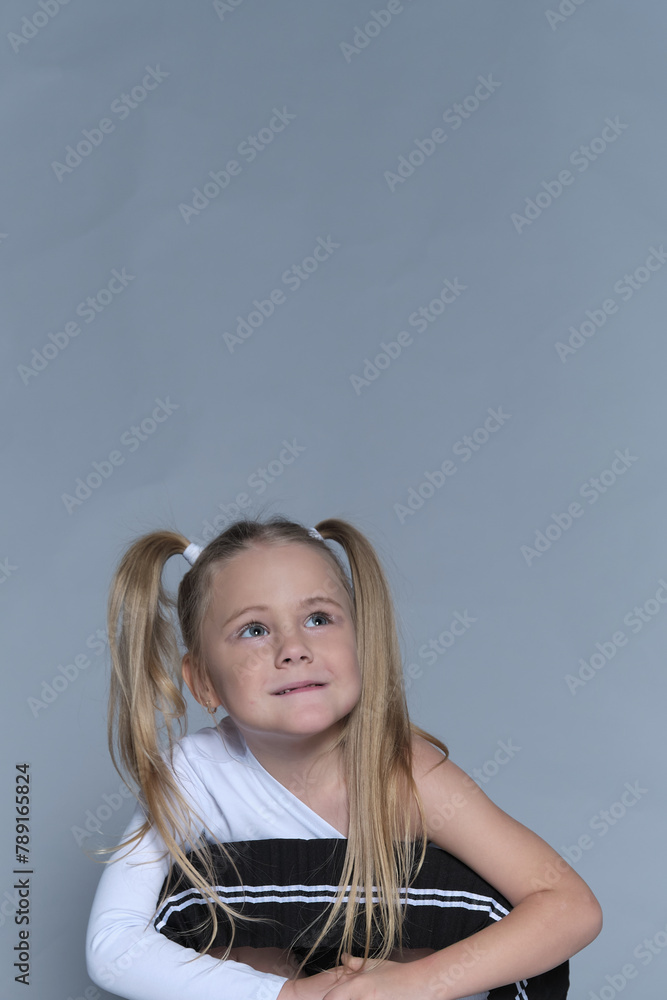 A thoughtful child with a subtle smile, her playful hairstyle adding to a pose full of character and youthful inquisitiveness. A thoughtful child with a subtle smile, her playful hairstyle adding to a pose full of character and youthful inquisitiveness.