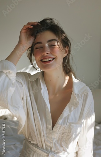 Woman in White Shirt Smiles on Bed