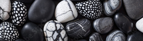 A close up of a pile of black and white rocks., banner photo