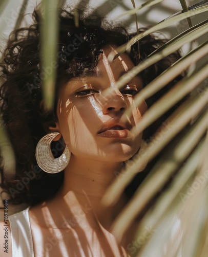 Woman Standing Under Palm Tree With Large Earrings